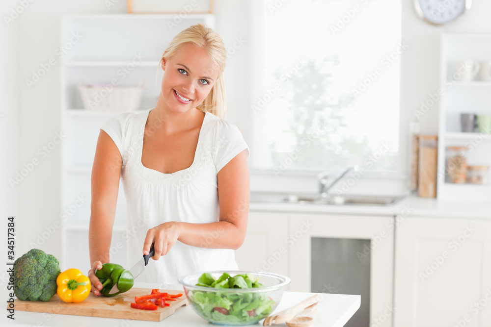 Wall mural good looking woman slicing pepper