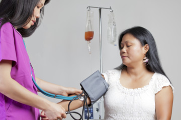 Asian nurse checking blood pressure