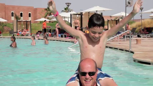 P&egrave;re et fils jouant ensemble &agrave; la piscine