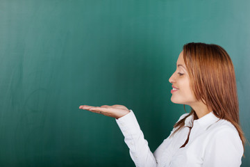 lächelnde junge frau hält etwas in der hand