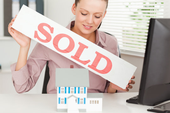 Businesswoman holding a sold sing