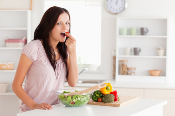 Obraz na płótnie Canvas Cute woman eating vegetables