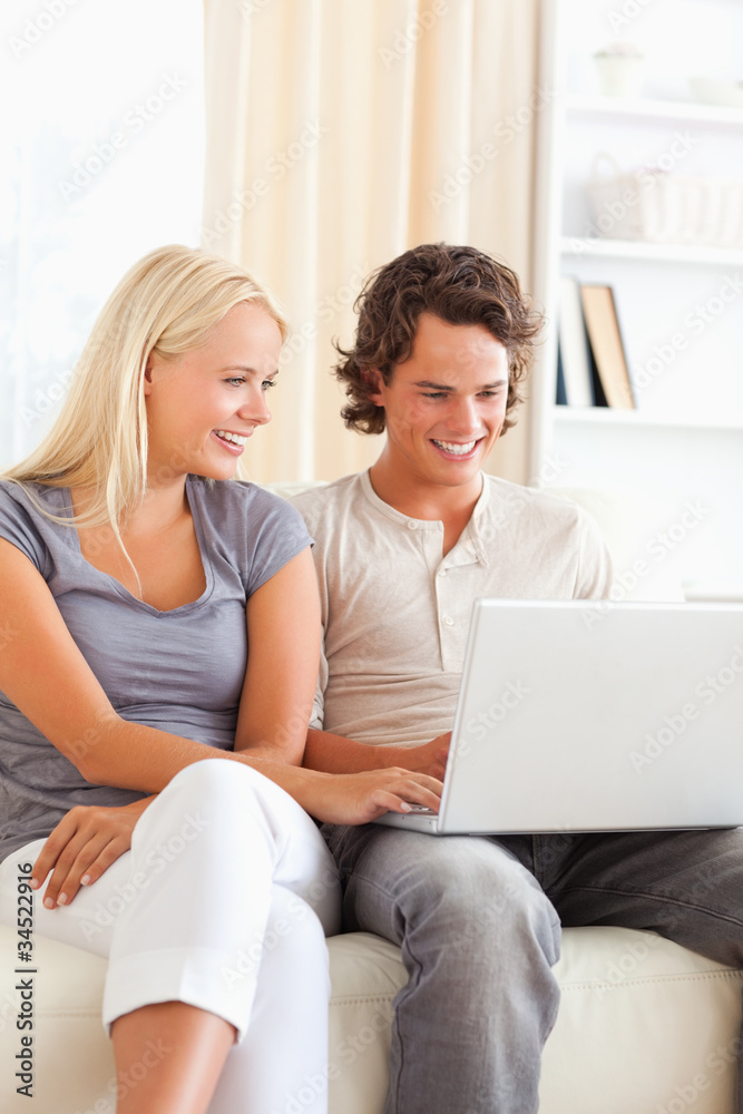 Poster portrait of a cute happy couple using a notebook
