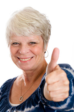 Happy, mature woman with a pretty smile giving a thumbs up