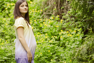 Naklejka na ściany i meble Beatiful young pregnant woman outdoor, in nature smiling
