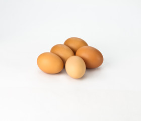 Five brown eggs on white