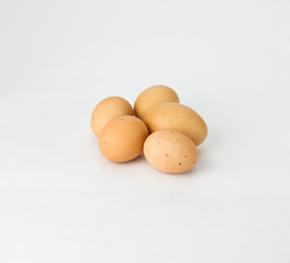 Five speckled brown eggs on white
