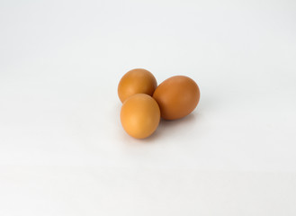 Three brown eggs on white