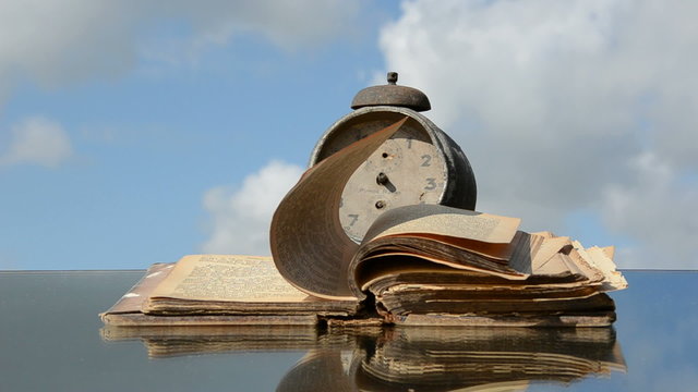 old book, vintage clock on mirror and wind
