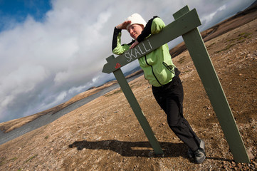 girl standing by the sign at Landmannalaugar, Iceland