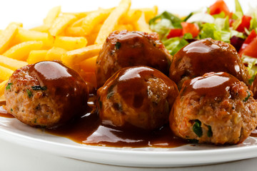 Roasted meatballs, French fries and vegetable salad