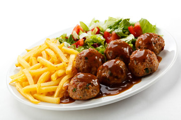 Roasted meatballs, French fries and vegetable salad