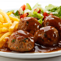 Roasted meatballs, French fries and vegetable salad