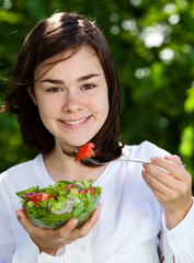 Girl eating vegetable salad
