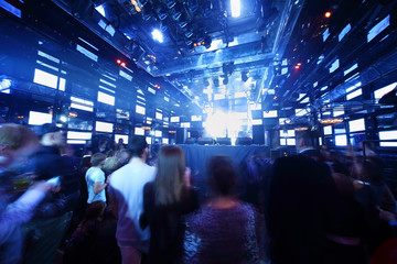 People dancing at concert in nightclub, light show