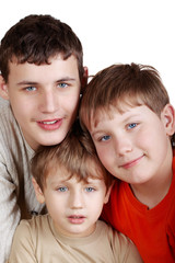 Close-up three smiling boys of different ages in colored t-shirt