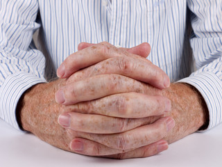 Man at desk, hands clasped