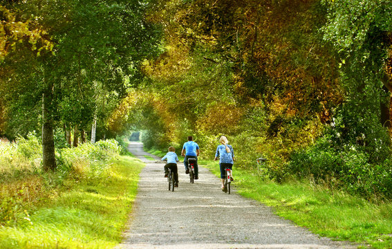 Fototapeta Familie mit dem Fahrrad unterwegs