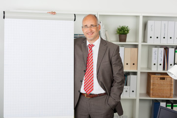 lächelnder mann steht am flipchart