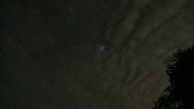 Time Lapse of rolling clouds under a starry night sky