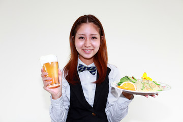 生ビールと料理を運ぶ笑顔のウエイトレス