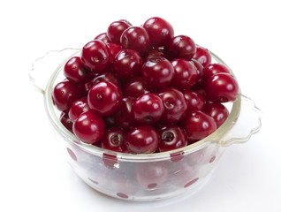 Bowl with ripe cherries. Isolated on a white background.