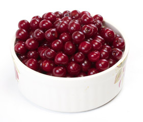 Bowl with ripe cherries. Isolated on a white background.