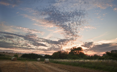 Fototapeta na wymiar Beautiful golden hour hay bales sunset landscape