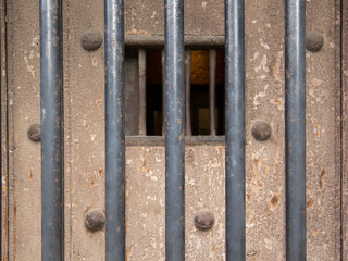Old prison door with metal bars and window