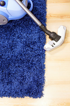 Vacuum cleaner stand  on blue carpet.