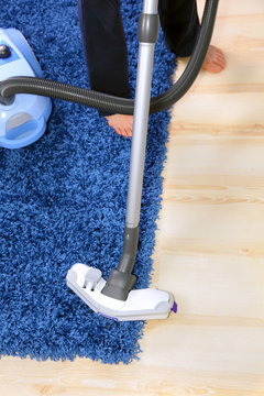 Vacuum cleaner in action-men cleaner a carpet.