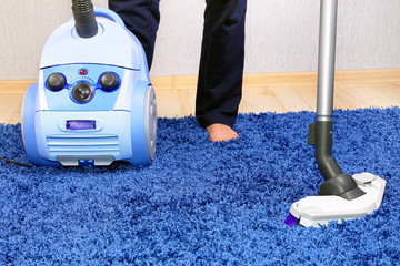 Vacuum cleaner in action-men cleaner a carpet.