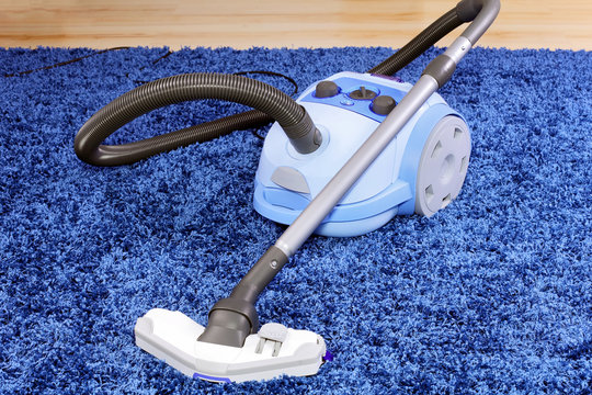 Vacuum cleaner stand  on blue carpet.