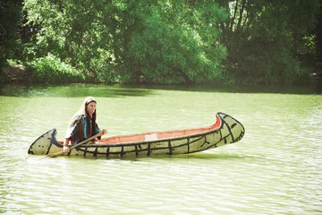 Foto op Canvas North American Indian floats down the river on a canoe © Shchipkova Elena