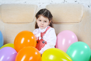 Fototapeta na wymiar girl sits on a sofa with balloons