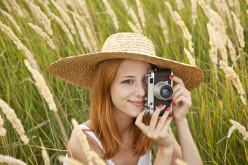 Redhead girl with old camera at outdoor.