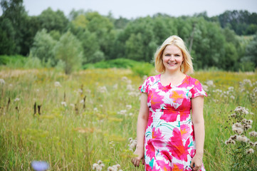 Outdoors portrait of beautiful blond woman in flower dress