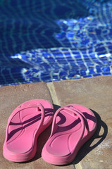 Zapatillas en el borde de una piscina