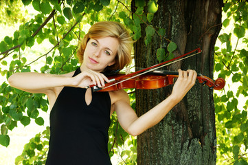 Pretty young woman playing the violin outdoor