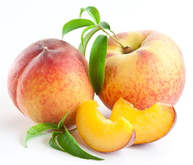 Ripe peach fruit with leaves and slises