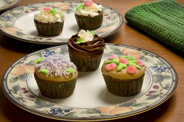 Ornately decorated cupcakes on plates
