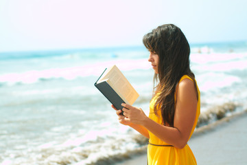 Young lady reading a book on the beach
