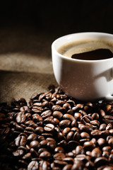 coffee beans with mug on a rough sacking