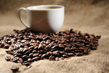 coffee beans with mug on a rough sacking