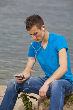 junger Mann mit Smartphone hört Musik