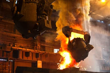 Foto op Canvas Smelten van metaal in metallurgische fabriek. Vloeibaar ijzer uit pollepel © Kekyalyaynen