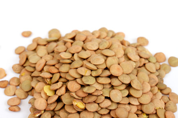 Pile of green lentils from low perspective isolated on white.