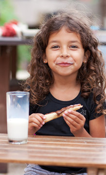Jeune fille souriante et son go&ucirc;ter