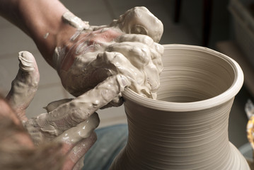 hands of a potter, creating an earthen jar on the circle
