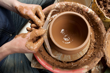 hands of a potter, creating an earthen jar on the circle